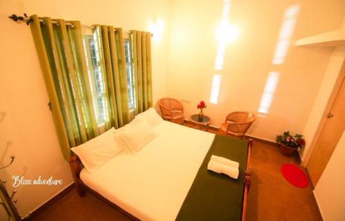 ViriparaにあるBreeze Hill resortのベッド1台と椅子2脚が備わる小さな客室です。