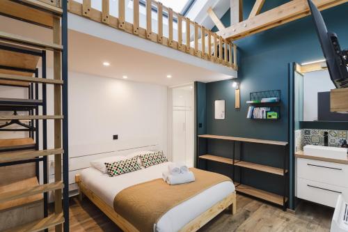 Dormitorio pequeño con litera y pared azul en Le Petit Chalet - Maison 2 chambres avec terrasse en Rennes