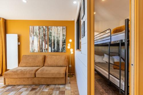 - un salon avec un canapé et des lits superposés dans l'établissement Le Clot Simo - Station des Angles vue montagne, aux Angles