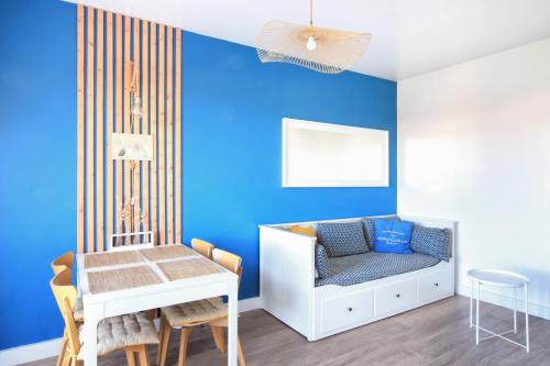- une chambre pour enfants avec des murs bleus, une table et une chaise dans l'établissement Terrasse de Chimay - Charmant apt dans résidence front de mer, à Barneville-Carteret