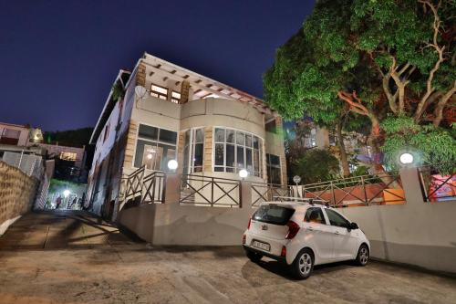 een witte auto geparkeerd voor een huis 's nachts bij Soul House in Durban
