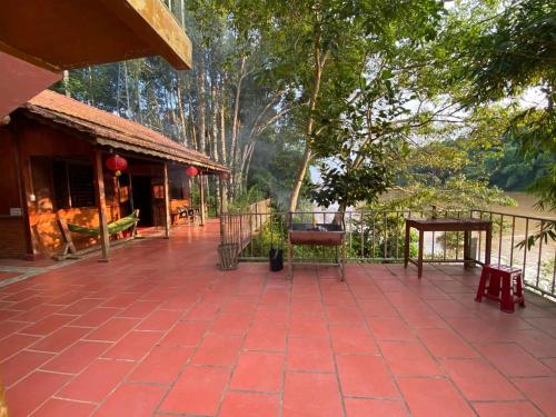 un patio exterior de una casa con una valla y árboles en Cát Tiên Riverside, en Tân Phú