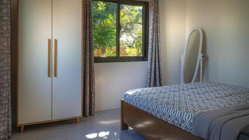 a bedroom with a bed and a dresser and a window at EspIliNorte, Stay and Play in San Juan