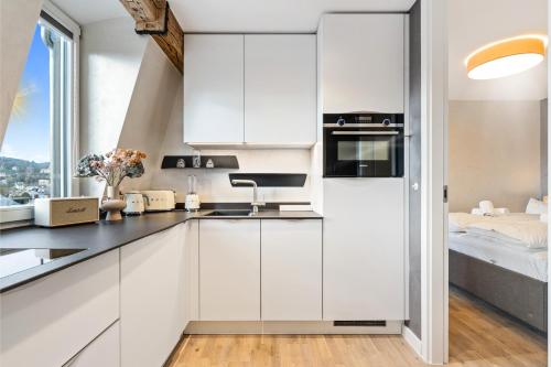 a kitchen with white cabinets and a window at Modern Elegance in historical City Center in Trier