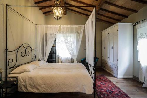 ein Schlafzimmer mit einem Himmelbett und einem Kronleuchter in der Unterkunft Casale Armonia in Massa Martana
