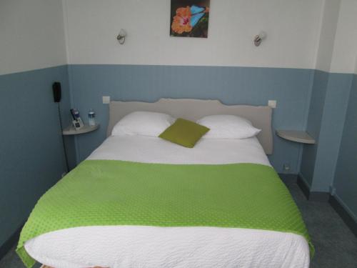 a bed with a green blanket and two pillows at Logis Hôtel Beauséjour in Chauvigny