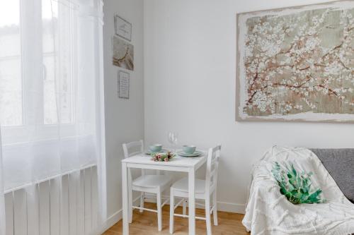 une salle à manger blanche avec une table et des chaises blanches dans l'établissement Le Serenity Paris, Stade de France, Le Bourget, à La Courneuve
