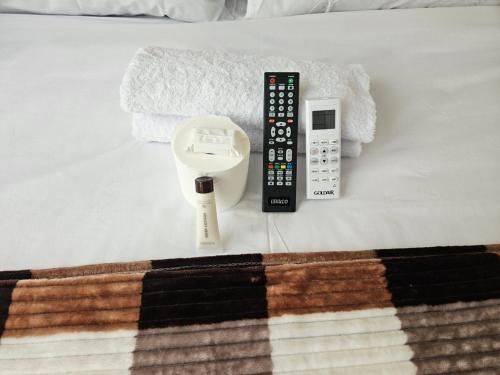 a remote control and a scale on a bed at DBrite in Pretoria