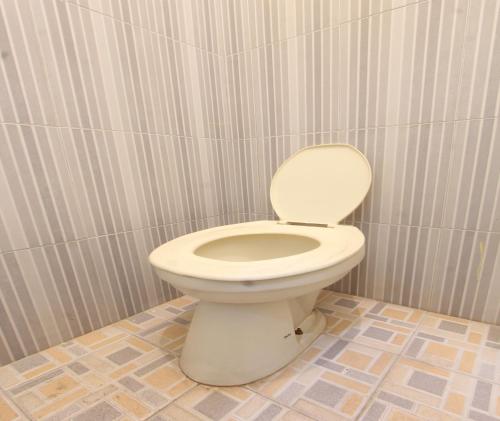 bagno con servizi igienici bianchi in camera di SPOT ON 93651 Losmen Ida a Lembuak