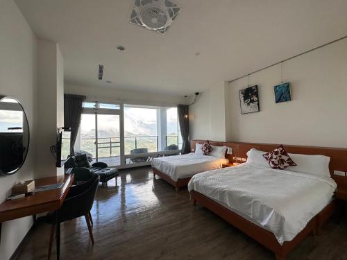 a bedroom with two beds and a desk and a window at SunSweet House in Fanlu