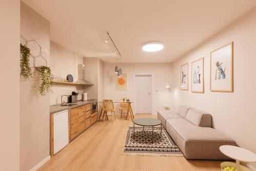 ein Wohnzimmer mit Couch und Küche in der Unterkunft GreyGreen by Holistay in Tirana