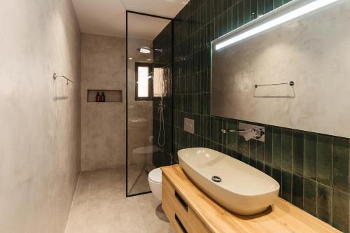 ein Badezimmer mit Waschbecken, Toilette und Dusche in der Unterkunft GreyGreen by Holistay in Tirana