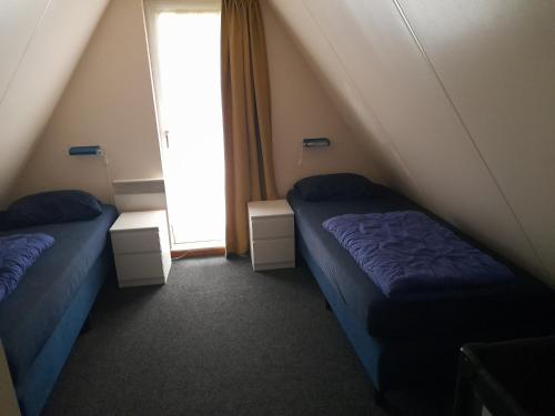 Zimmer mit 2 Betten und einem Fenster im Dachgeschoss in der Unterkunft t'Hoog Holt in Gramsbergen