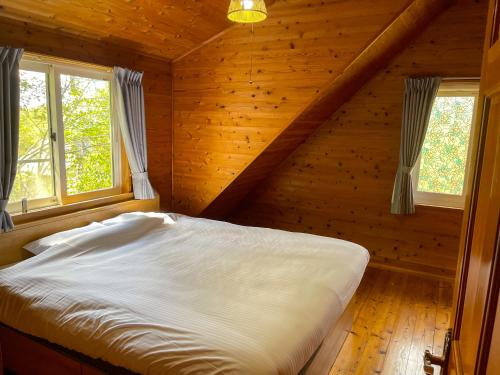 忍野村的住宿－【富士ビューロッジ】自然豊かなBBQ体験！一棟貸しログハウス，小木屋内一间卧室,配有一张床