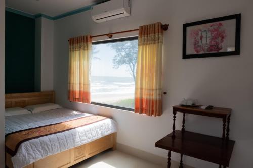 une chambre avec un lit et une grande fenêtre dans l'établissement Suối Nước Resort, à Ấp Long Sơn