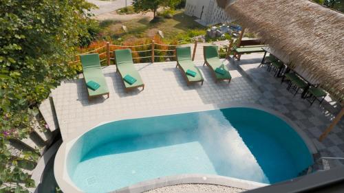 vista sul tetto di una piscina con sedie a sdraio e tetto di paglia di Villa La Jade Chaweng Noi 2BR a Chaweng Noi Beach