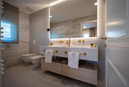 a bathroom with a sink and a toilet and a mirror at Cascade Luxury Apartments in Dubrovnik