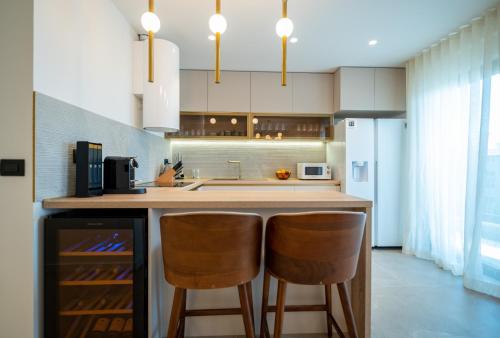 a kitchen with two bar stools and a counter top at Cascade Luxury Apartments in Dubrovnik