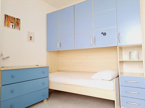Palumbo的住宿－Villino due palme，一间设有蓝色橱柜和一张床的小卧室