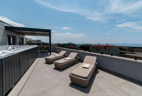 a balcony with lounge chairs on a roof at Cascade Luxury Apartments in Dubrovnik