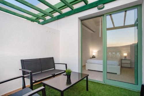 ein Wohnzimmer mit einem Sofa und einem Tisch in der Unterkunft Casa David Prieto 2 Habitaciones in Caleta de Fuste