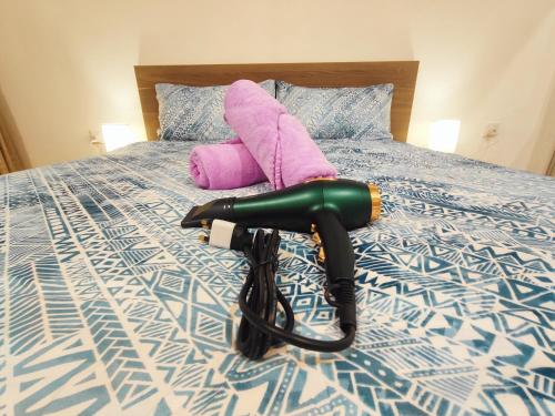 a blow dryer is laying on a bed at SoulHealingPlace Galacity 2BR 3Bed Apartment in Kuching