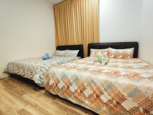 a bedroom with two beds with stuffed animals on them at SoulHealingPlace Galacity 2BR 3Bed Apartment in Kuching