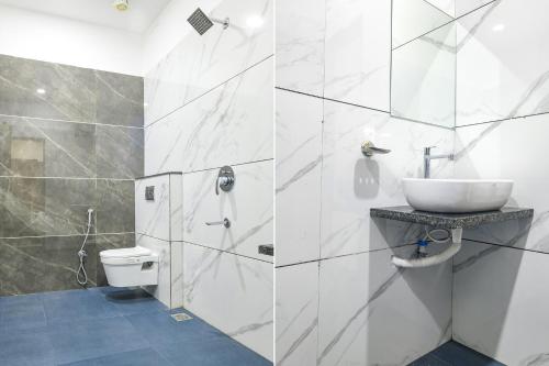 a white bathroom with a sink and a toilet at FabHotel Grand Giriraj in Indore