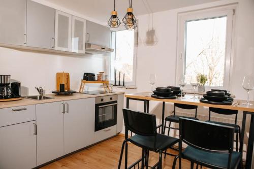 a kitchen with white cabinets and a table with chairs at Modern & black - City - Netflix - Wifi - 4 Person in Bochum