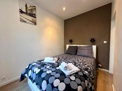 een slaapkamer met een bed met handdoeken erop bij Escalille la Travia in Lille