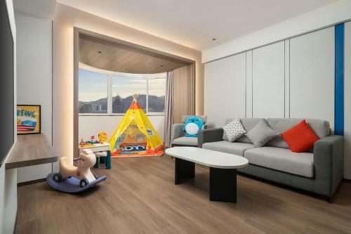 uma sala de estar com um sofá e um brinquedo infantil em Holiday Inn Express Xiamen Lushan -Shopping Center, an IHG Hotel em Xiamen