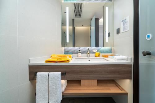 a bathroom with a sink and a large mirror at Holiday Inn Express Xiamen Lushan -Shopping Center by IHG in Xiamen