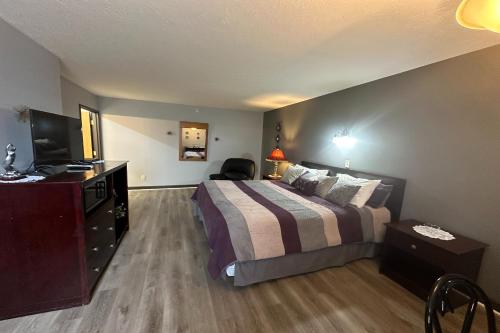 a hotel room with a bed and a television at Fairway Inn Florence Indiana in Florence