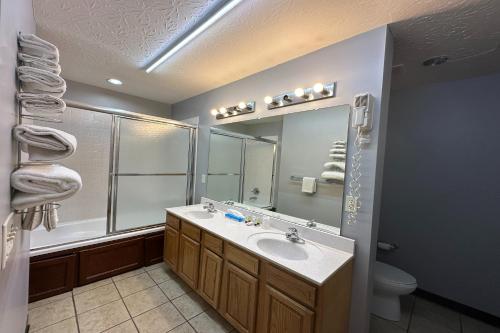 a bathroom with a sink and a mirror and a toilet at Fairway Inn Florence Indiana in Florence