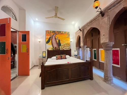 um quarto com uma cama com um quadro na parede em Karma homestay em Jodhpur