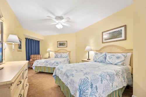 a bedroom with two beds and a ceiling fan at Beachfront Luxury Villa Ocean Walk Resort Daytona in Daytona Beach