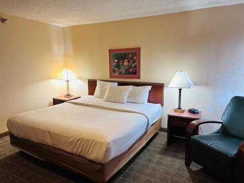 ein Hotelzimmer mit einem Bett und einem Stuhl in der Unterkunft Norwood Inn Statefare Grounds in Indianapolis