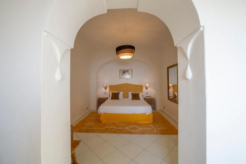una camera da letto con un letto in una stanza bianca di Aria di Mare,near elevator, few steps, parking, garden a Positano