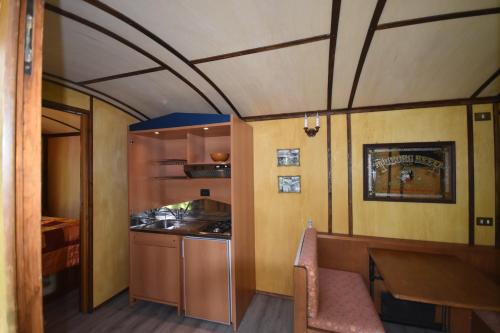 a room with a table and a kitchen in a train at terrebio bungalow in Visnadello