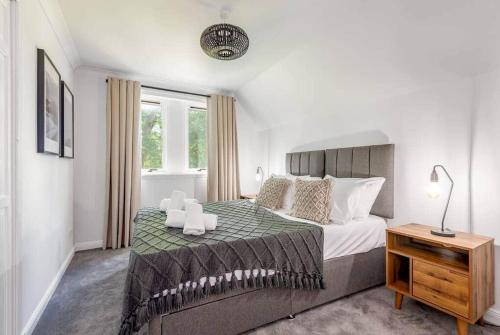 a bedroom with a large bed with two candles on it at Abbey Villa - Stylish House - Central with Parking in St. Andrews