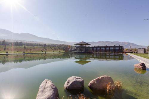 a lake with rocks in front of a building at Arman Dala Resort in Qaskeleng