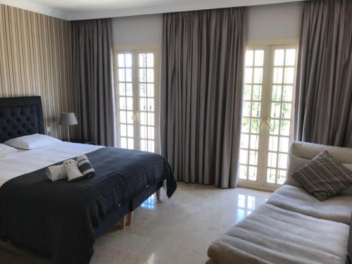 ein Hotelzimmer mit einem Bett und einem Sofa in der Unterkunft Aloha Pueblo with sea views in Marbella