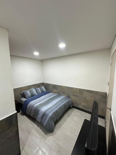 a bedroom with a bed and a tv in it at APARTA/ESTUDIO INDEPENDIENTE GALERIAS-CHAPINERO in Bogotá