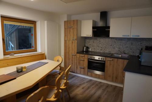 a kitchen with a wooden table and a table and chairs at Ferienhaus Marian in Neustift im Stubaital