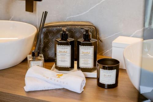 a bathroom counter with three bottles of soap and a sink at Villa Contessa - Top 200 ultra luxury world villas in Mali Lošinj