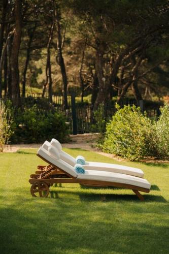a bench sitting in the grass in a park at Villa Contessa - Top 200 ultra luxury world villas in Mali Lošinj