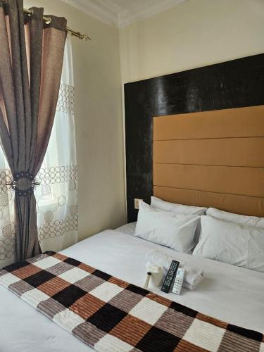a bedroom with a bed with a remote control on it at DBright Lodge in Pretoria