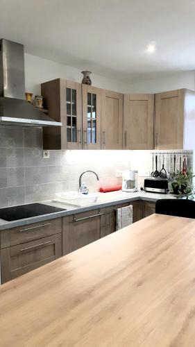 a kitchen with wooden cabinets and a wooden counter top at La Maison du Gaillard in Chitenay