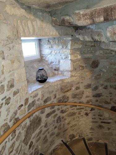 a stone staircase with a vase in a stone wall at Auberge de la vallée de la douve in L'Etang-Bertrand