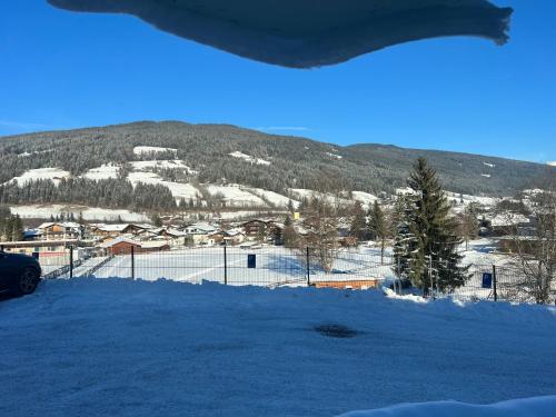 a snow covered field with a mountain in the background at Haus Schlatti in Altenmarkt im Pongau